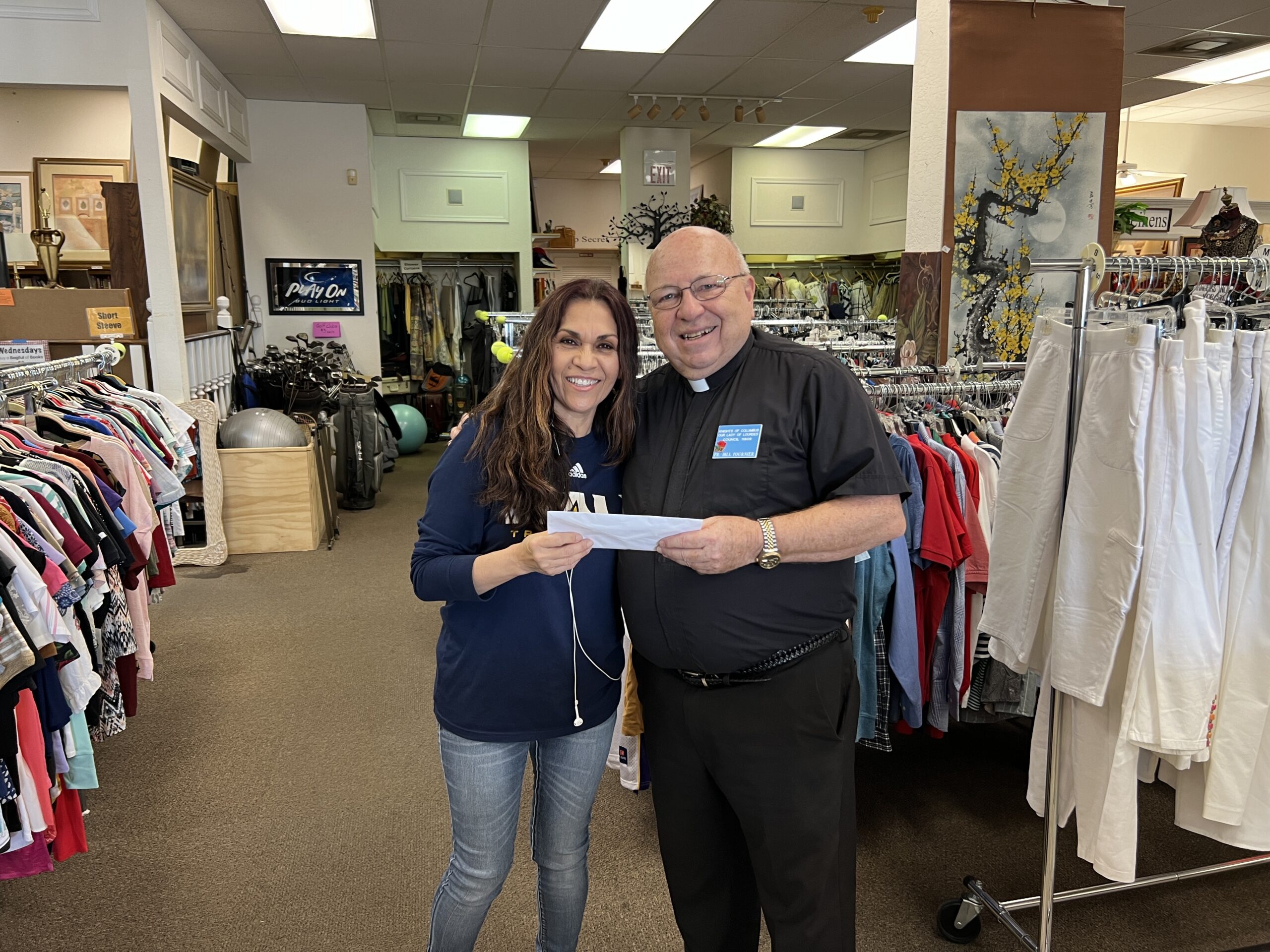 Event chair, Fr. Bill Fournier, presenting Carmen with the $2,750 check donation to Valley View Community Food Bank & Thrift Store